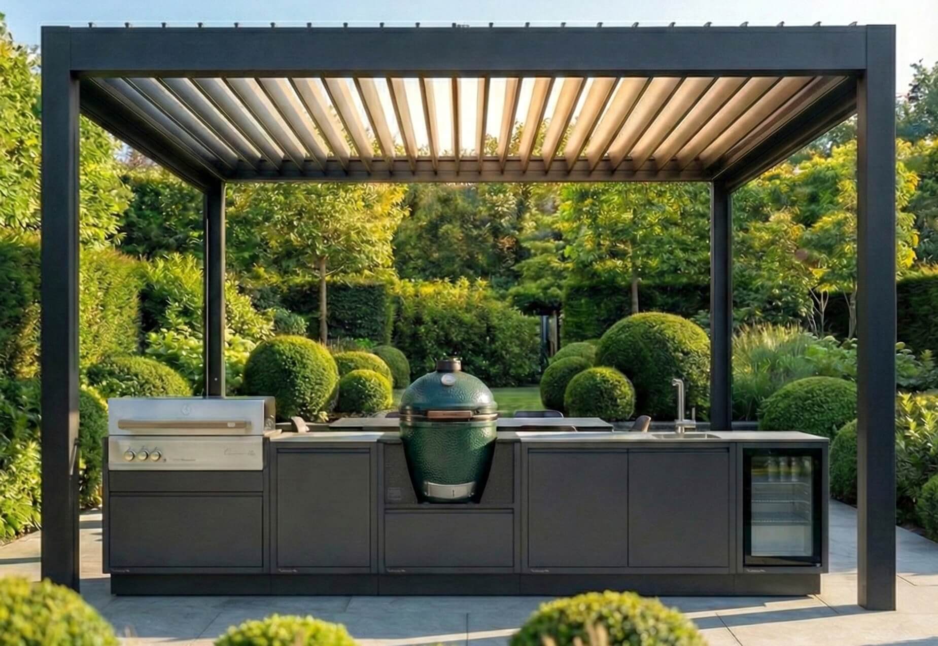 Antracitszürke Burn Lux prémium kültéri konyha beépített gázgrillel, zöld Big Green Egg kamado grill sütővel, mosogatóval és hűtővel, modern lamellás pergola alatt, elegáns kertben.